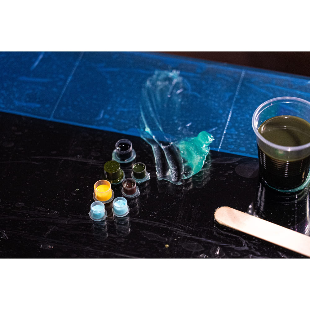INK-EEZE Green Tattoo Ointment artist applying during tattoo session with protective healing properties.