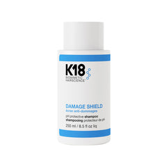 K18 Damage Shield Shampoo bottle demonstrating color-safe cleansing for vibrant, healthy hair.