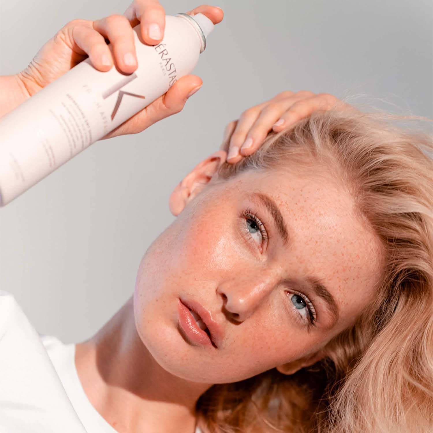 KÉRASTASE Fresh Affair aerosol can in powdery mist effect over hair.