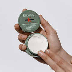 KÉRASTASE Genesis Homme wax being raked through hair for even texture.