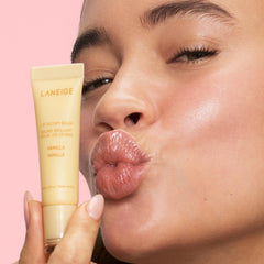 LANEIGE vanilla Lip Glowy Balm tube in hand ready for easy daytime application