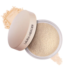 Laura Mercier Ultra-Blur powder jar closeup reveals pore-blurring translucent finish.