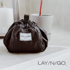 Lay-n-Go Cosmo bag folded flat fits neatly in a suitcase while traveling.