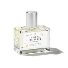 Le Monde Gourmand Copal de Terre bottle close-up with amber glow for daily fragrance ritual.
