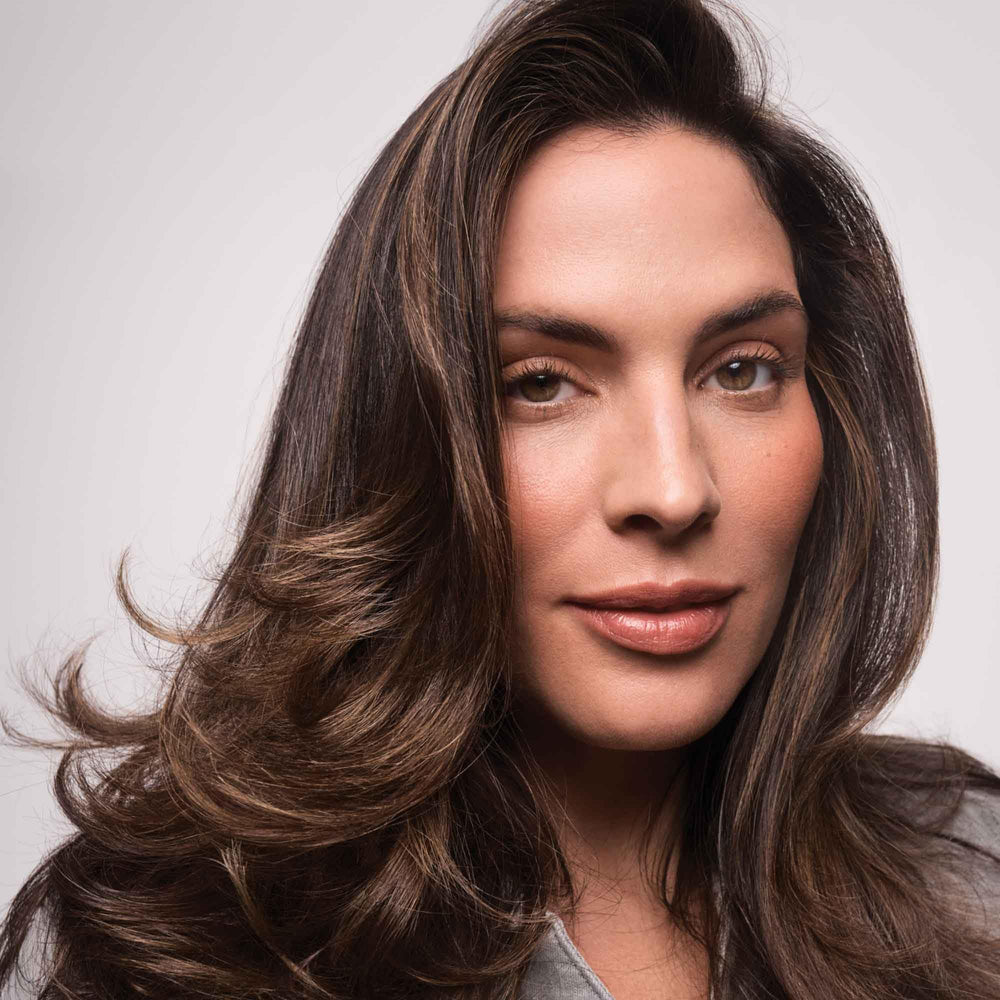 Living proof Full Volume Root-Lifting Spray on hair showing styled look with shine.