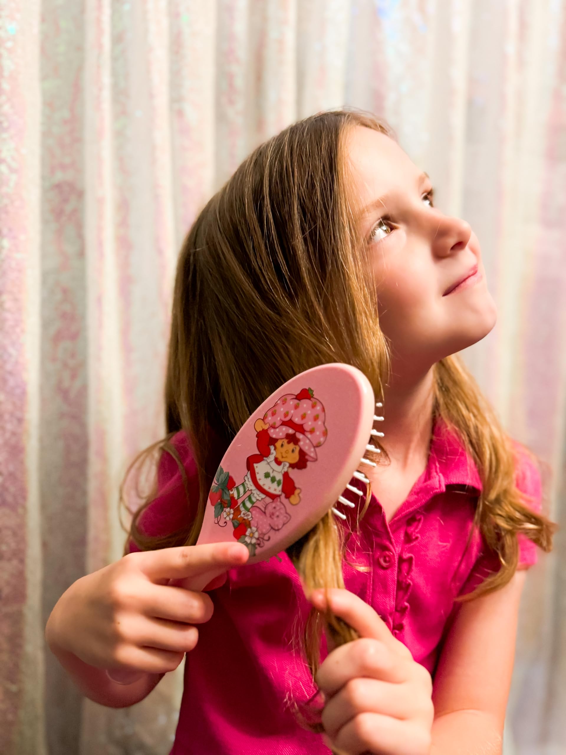 LUV HER close-up display of Strawberry Shortcake hair accessories in use.