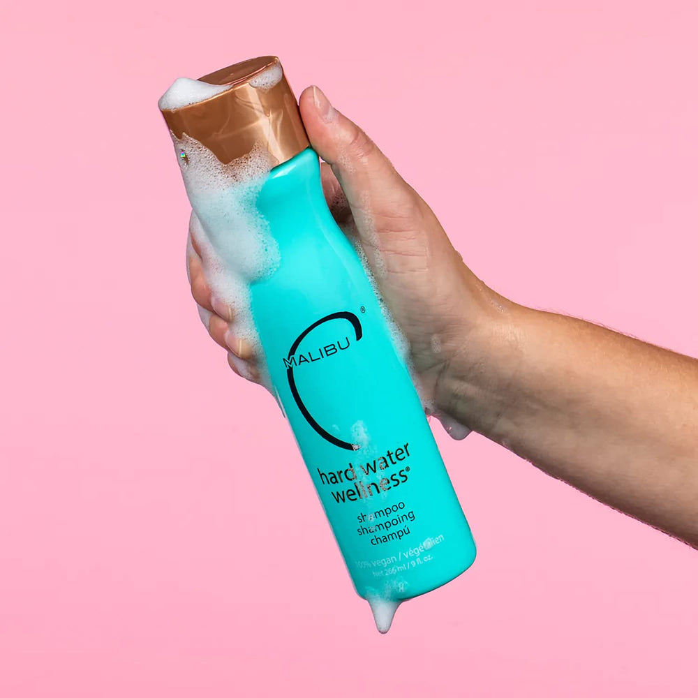 Malibu C Hard Water Wellness Shampoo label closeup highlights mineral protection and color-safe cleansing