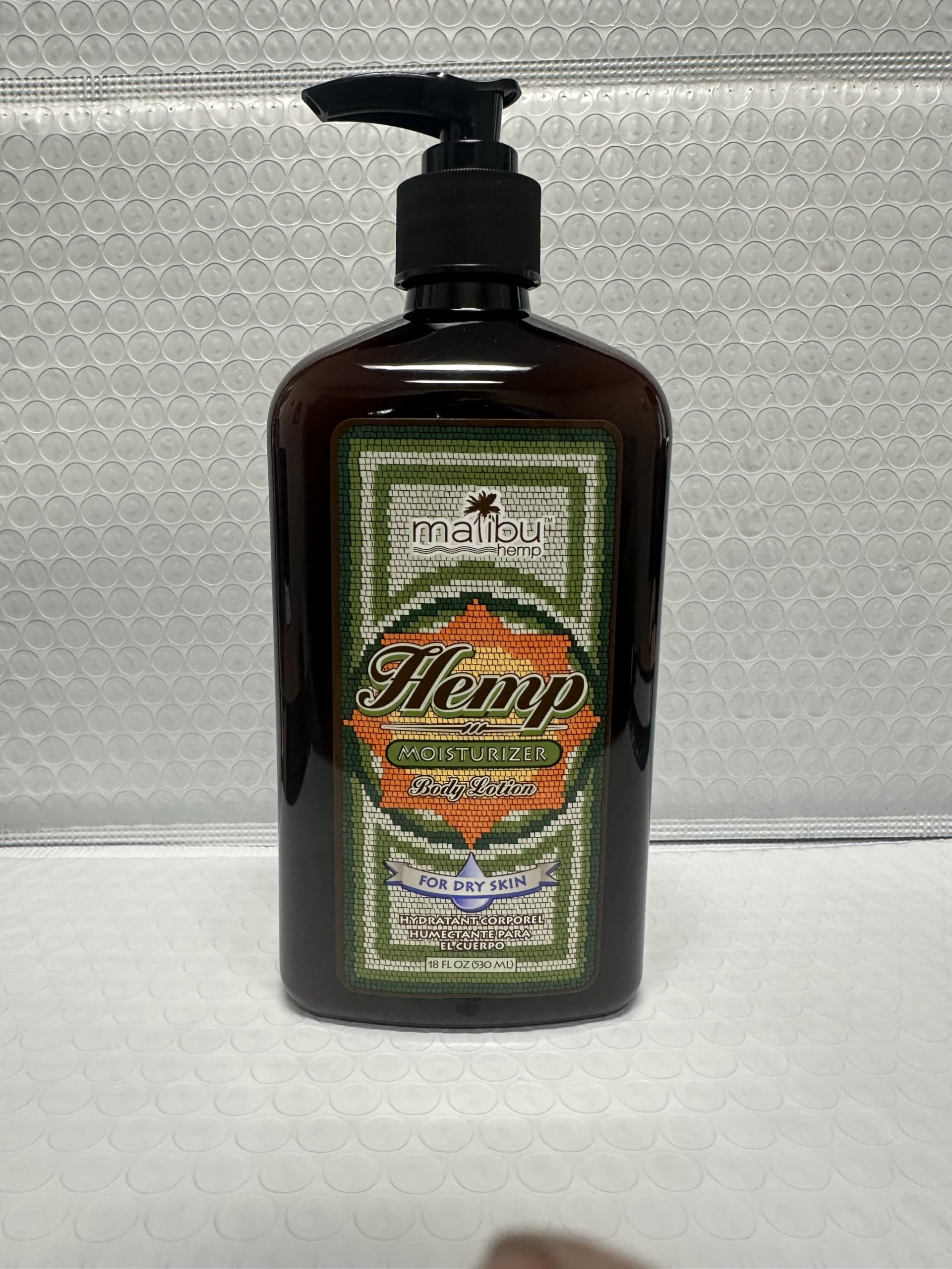 Malibu Tan Body Lotion bottle closeup highlights brand label and ingredients.