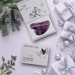 Mount Lai Amethyst Gua Sha on cheeks promoting gentle contouring and refreshed skin