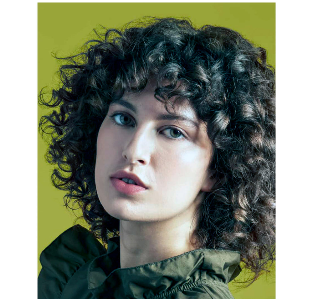 Native Curl Care shampoo bottle with natural glow demonstrates vegan and cruelty-free branding