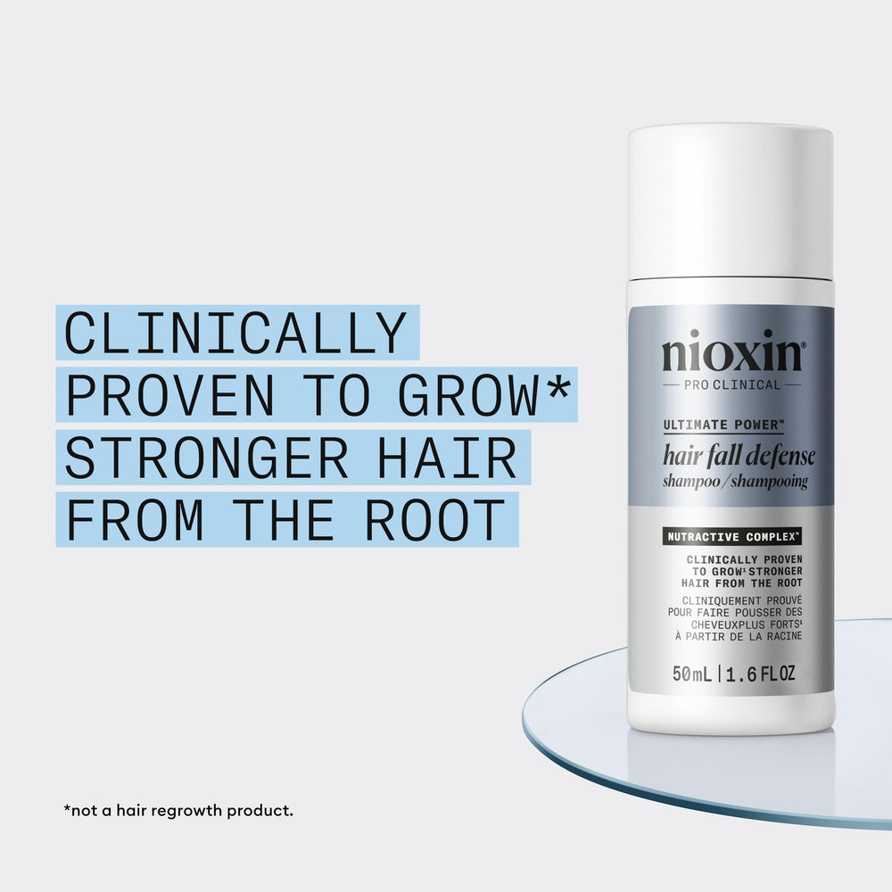 Hand holding NIOXIN 50mL bottle to show compact travel-friendly size benefit
