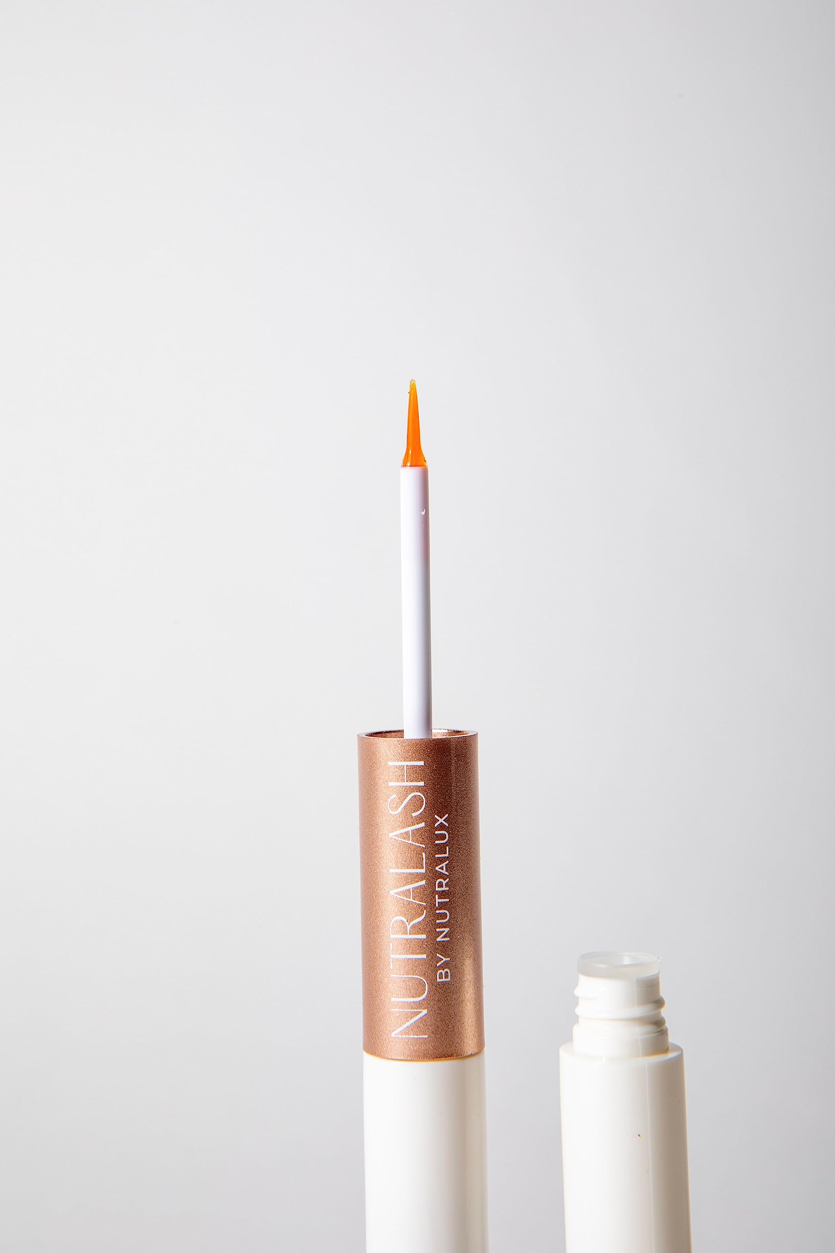 NutraLux NutraLash close-up wand applying on brow line shows targeted use.