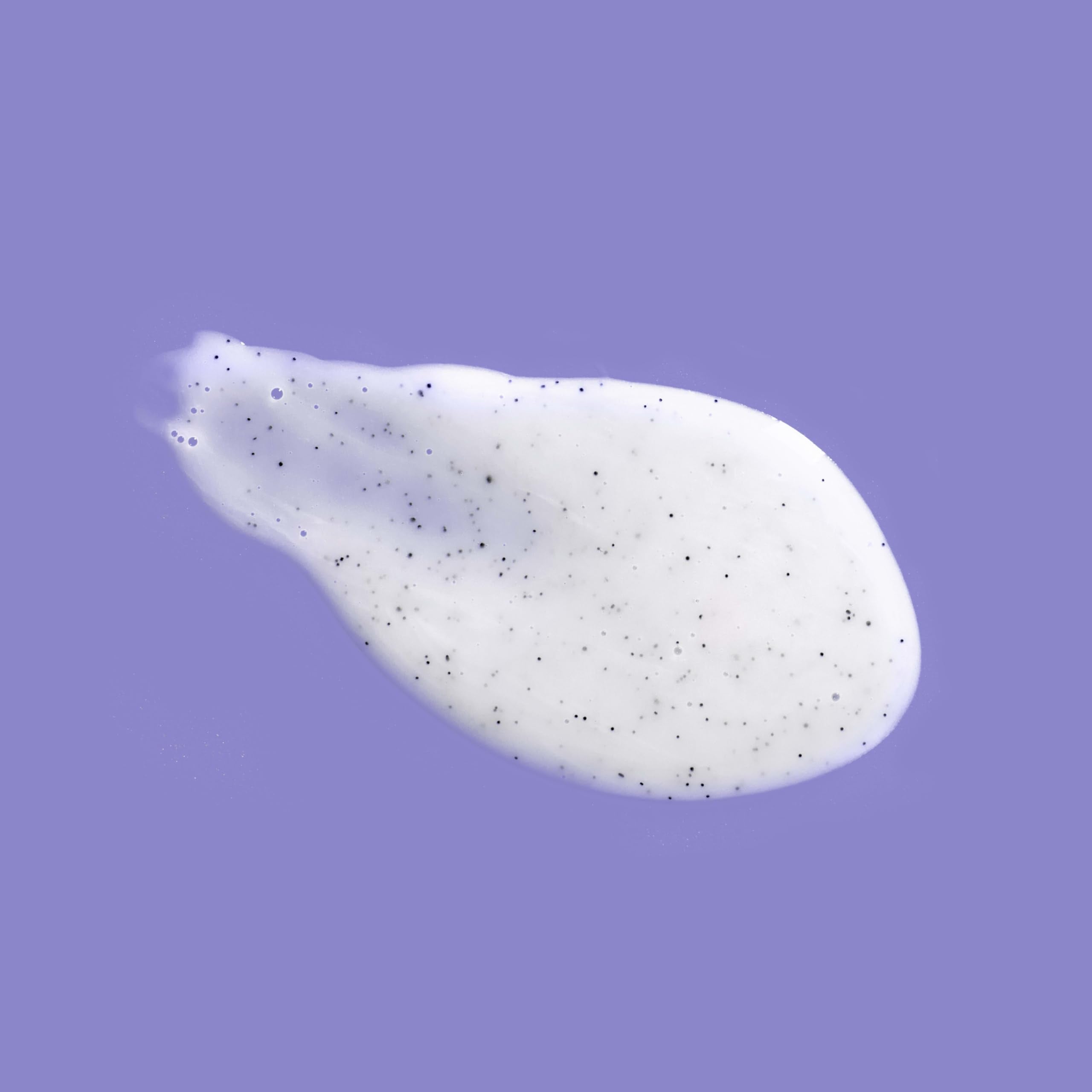 OGX Calming Amethyst Lavender bottle with lavender flowers for aromatherapy-inspired shower.