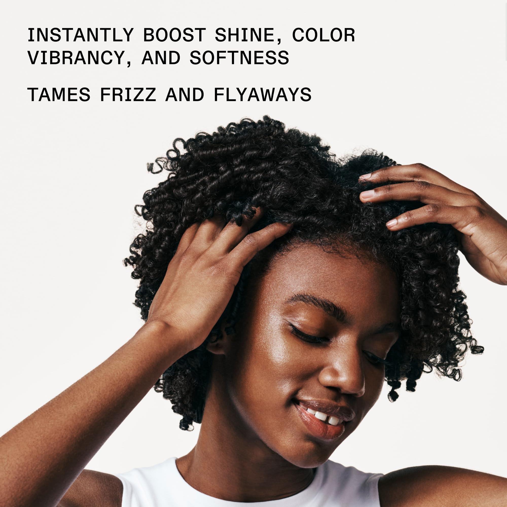 stylist applying Olaplex No.7 to damp hair mid-lengths demonstrating frizz control and manageability