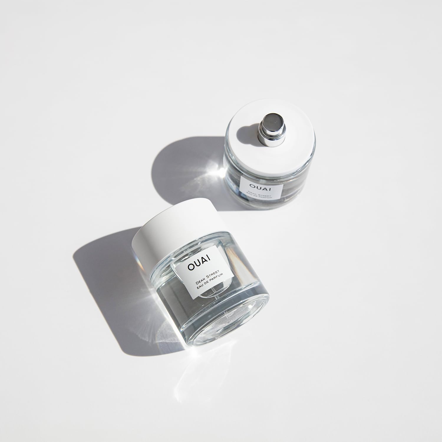 OUAI Dean Street perfume bottle captured with subtle mist suggesting day-to-night versatility.