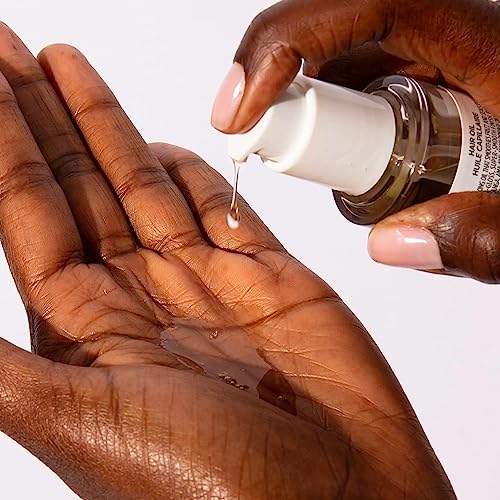 OUAI hair oil droplets on a strand show a glossy, hydrated finish.
