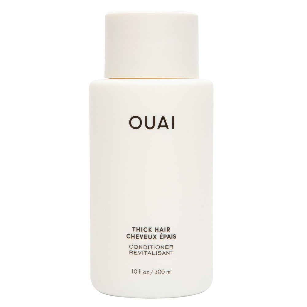 OUAI Thick Hair Conditioner bottle pouring for detangling and frizz control.