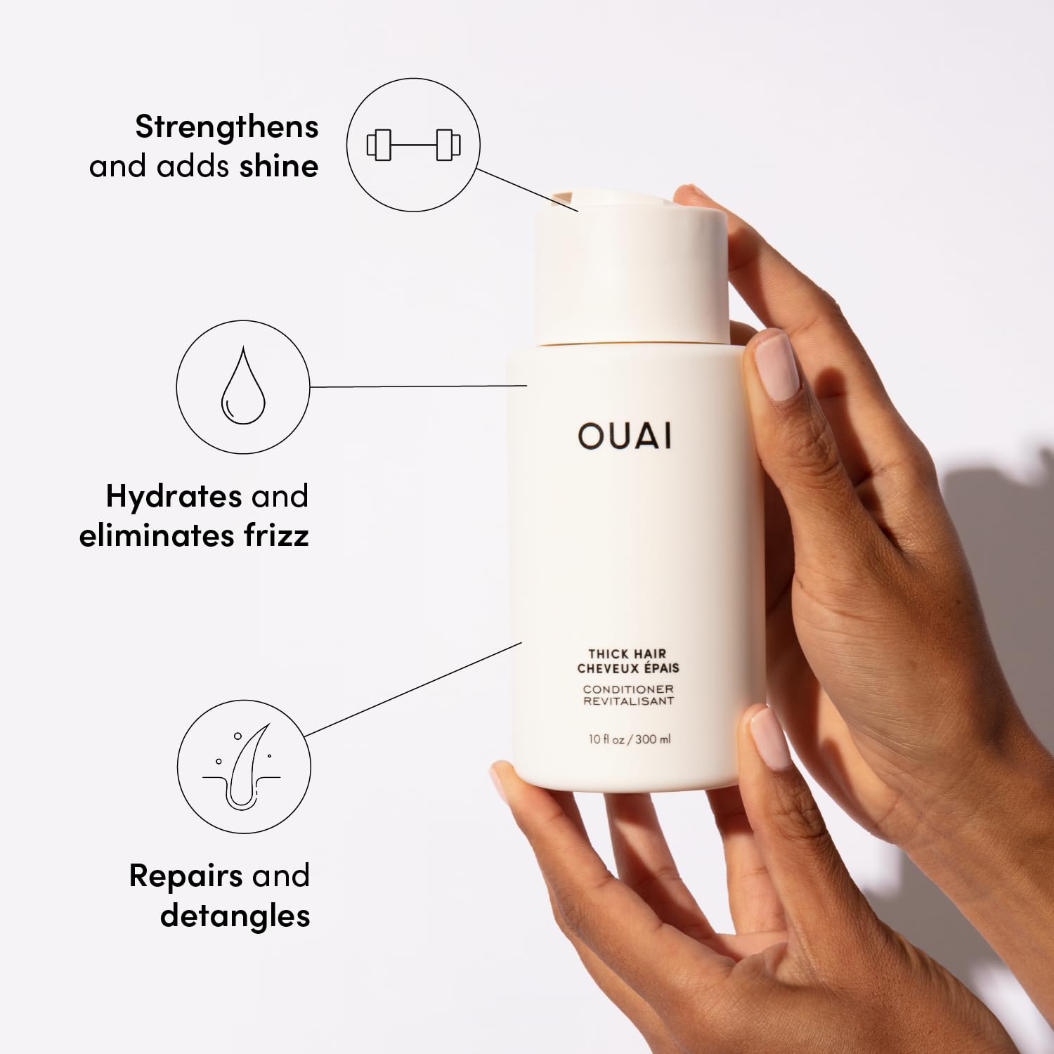 OUAI Thick Hair Conditioner hands rubbing to show creamy hydration texture.