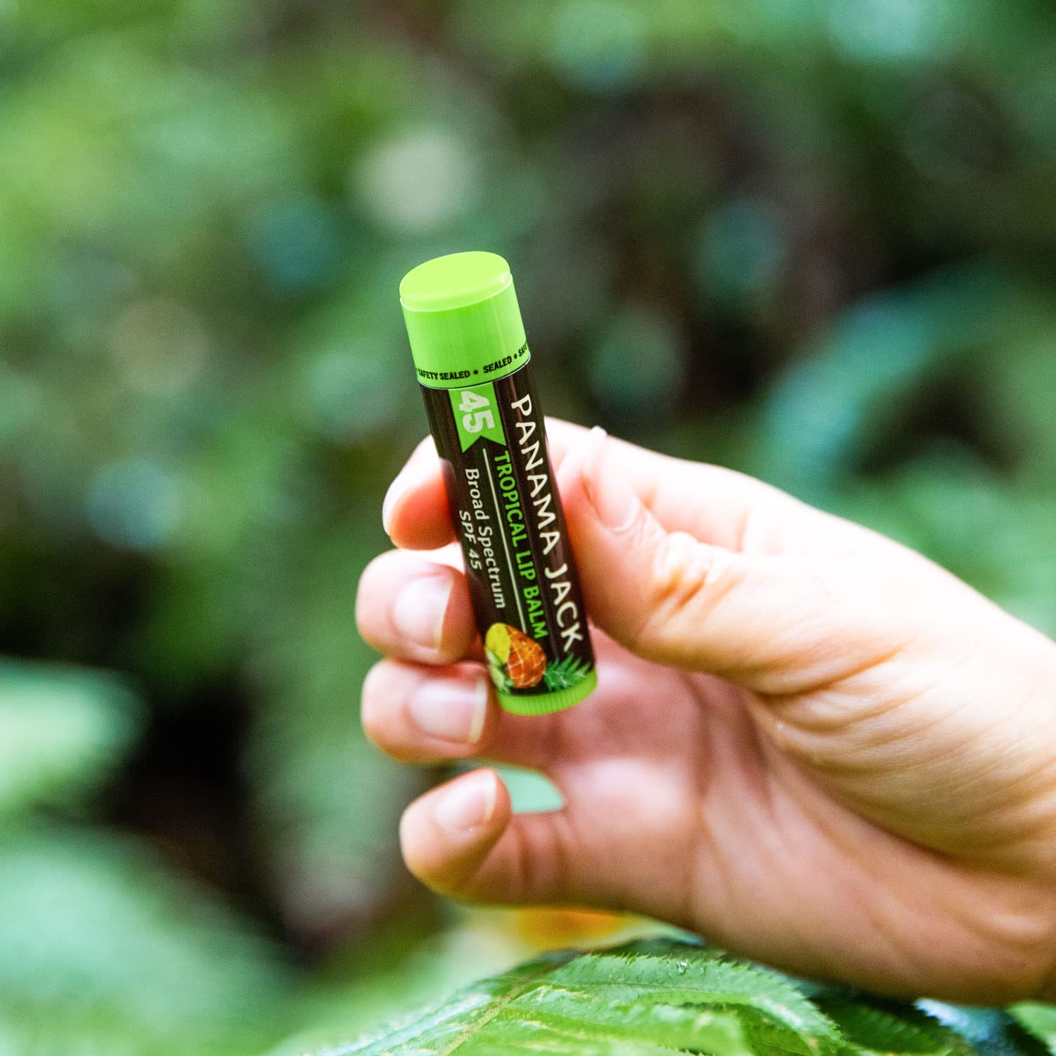 Panama Jack Lip Balm being applied on lips during sunny day outdoors.