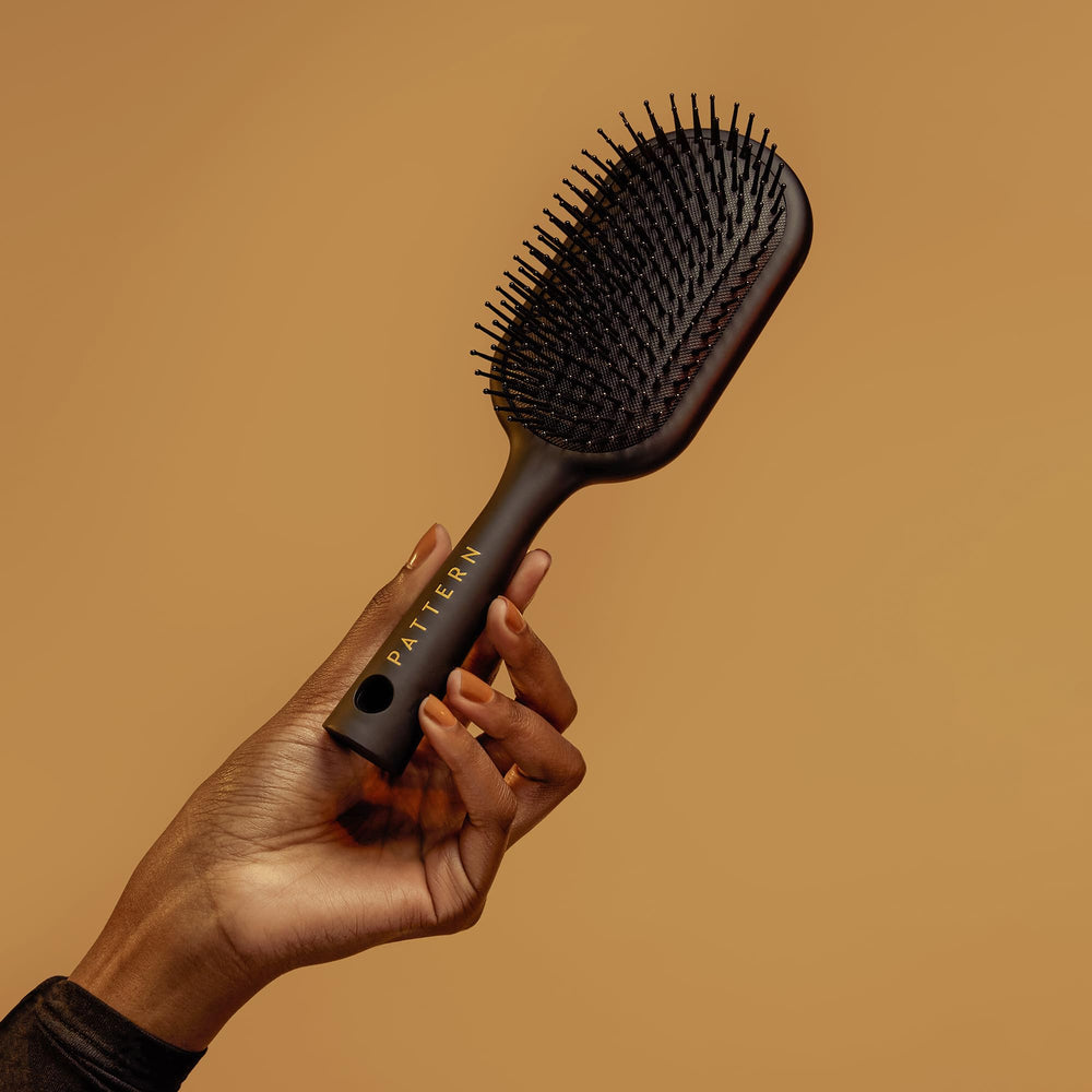 PATTERN Beauty paddle brush detangling-action showcases easy-clean matte handle.