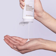 Paul Mitchell Repair Conditioner bottle pour demonstrates easy detangling preparation