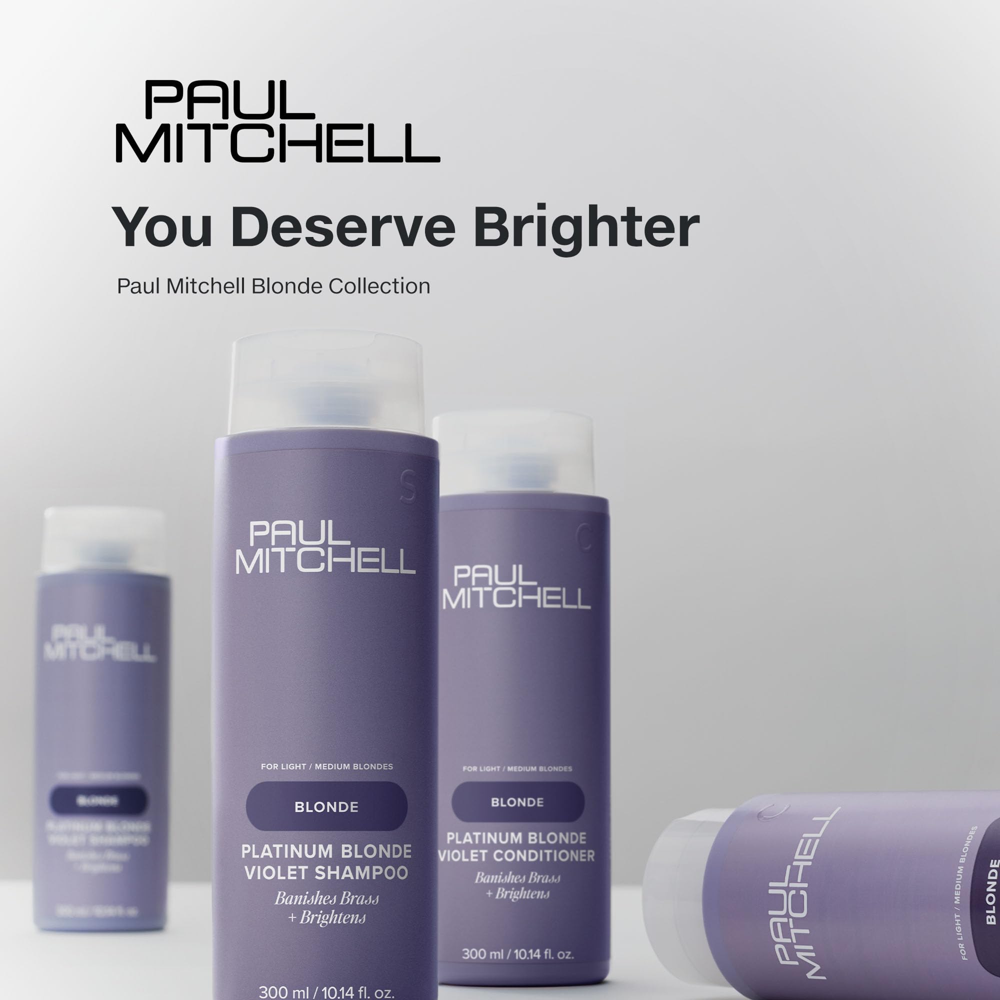 Paul Mitchell Platinum Blonde Violet Conditioner bottle under light reveals cool-bright tones.