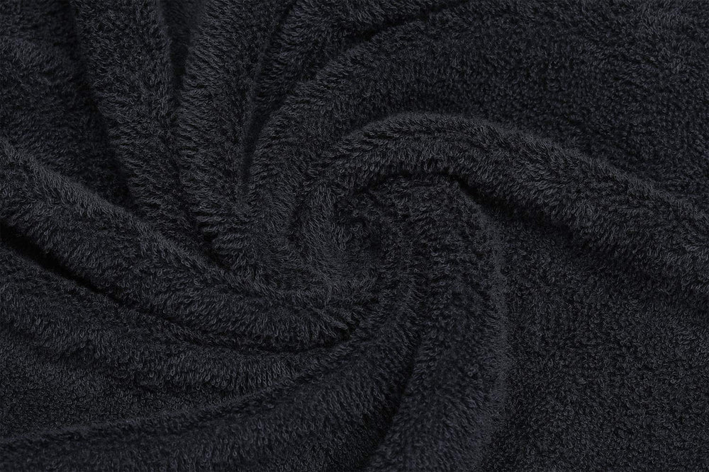 PERFEHAIR Black Salon Towels draped over a spa table emphasize spa-grade softness.