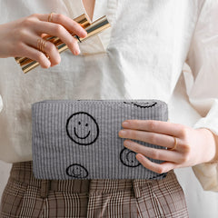 Photect smile-face bag opened to reveal compact interior for cosmetics.