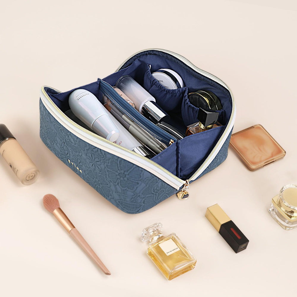 Prite cosmetic bag in blue flower being opened over sink demonstrating wipe-clean vegan leather