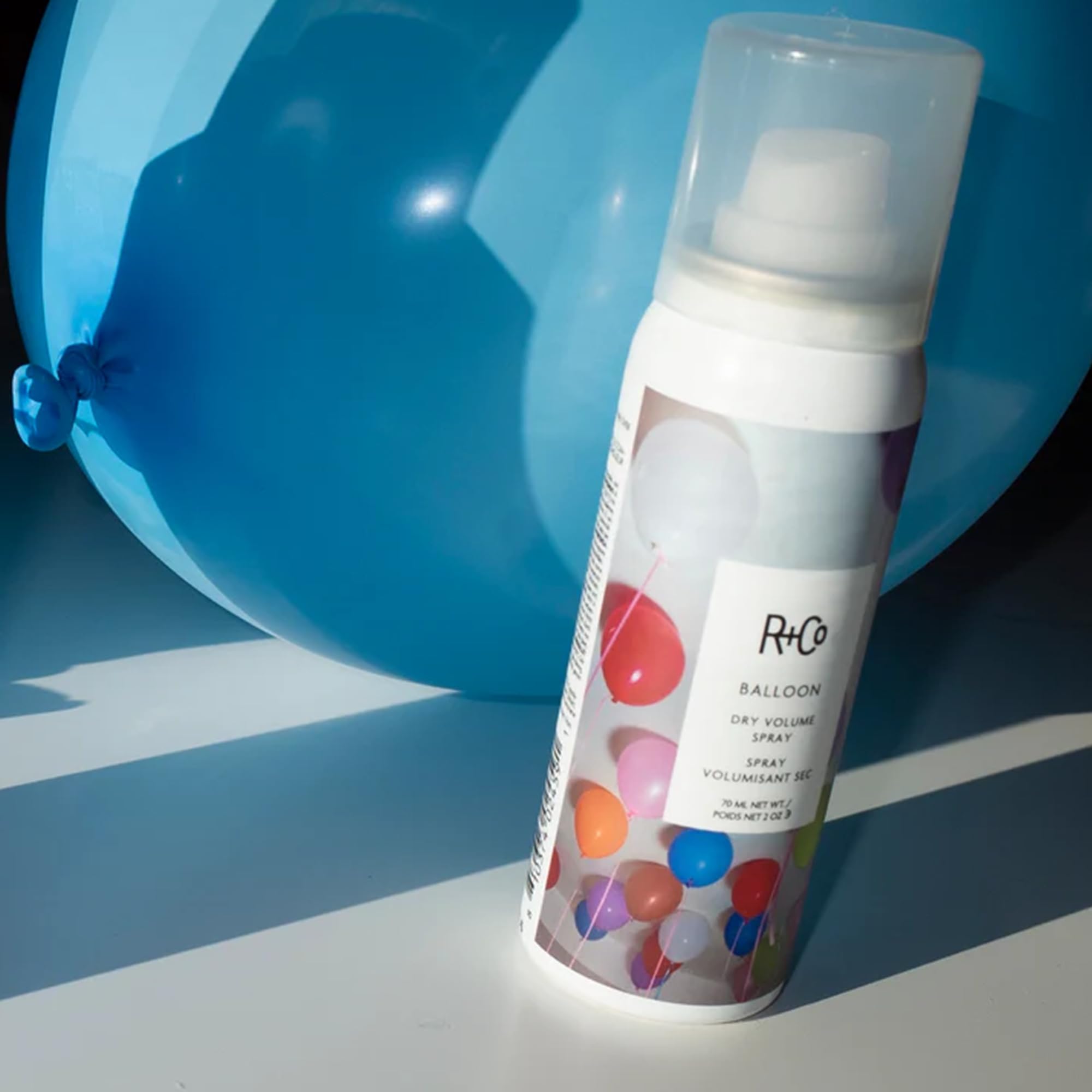 Model with voluminous, bouncy hair created by R+Co Balloon Dry Volume Spray.