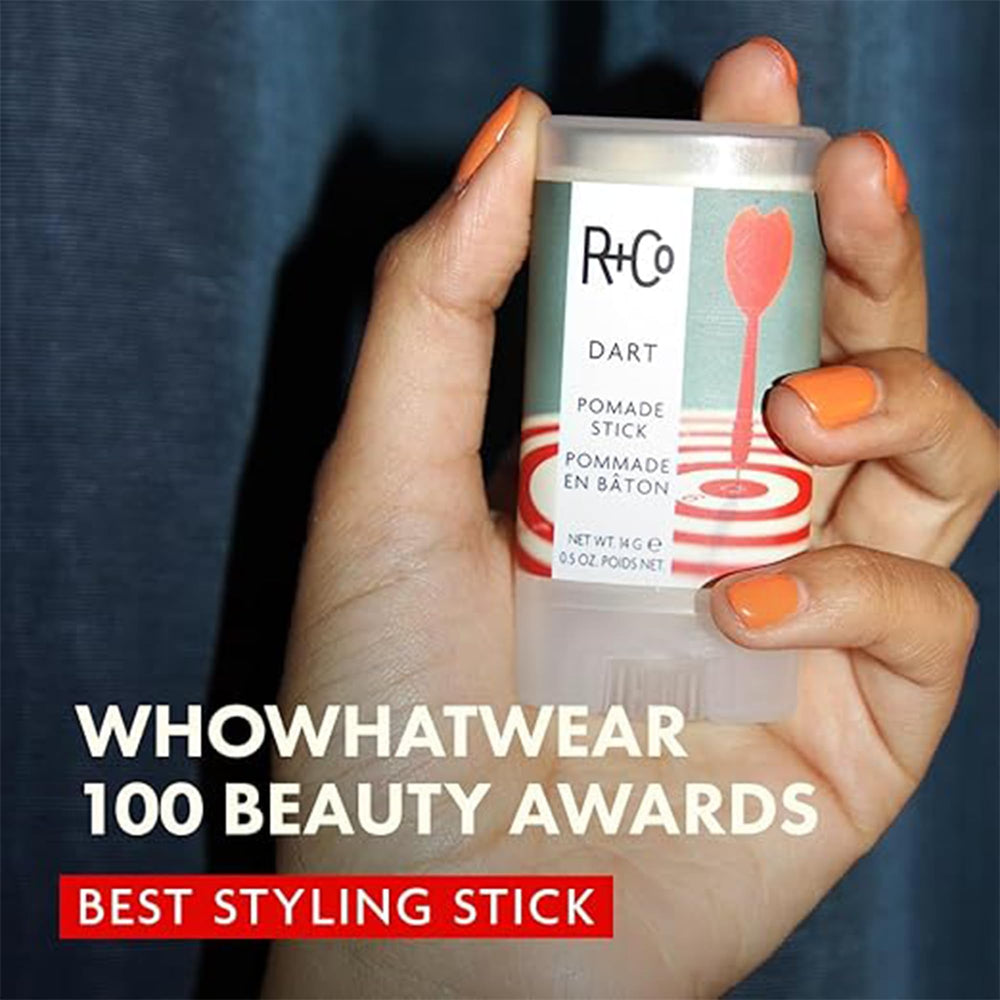 R+Co Dart Pomade Stick smoothing strands for a sleek, defined look.