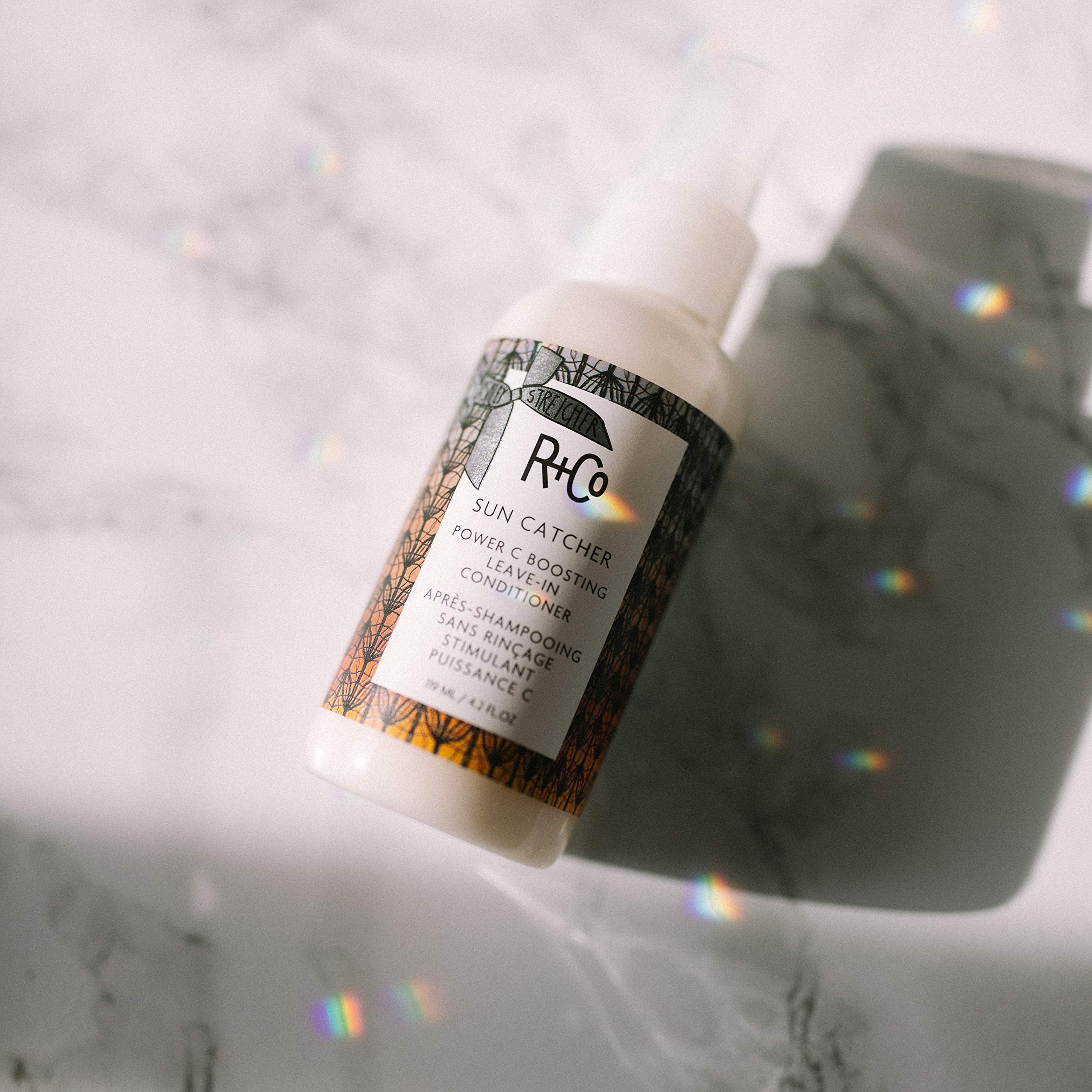 R+Co Sun Catcher Power C Leave-In bottle back highlights lightweight conditioning for hair.