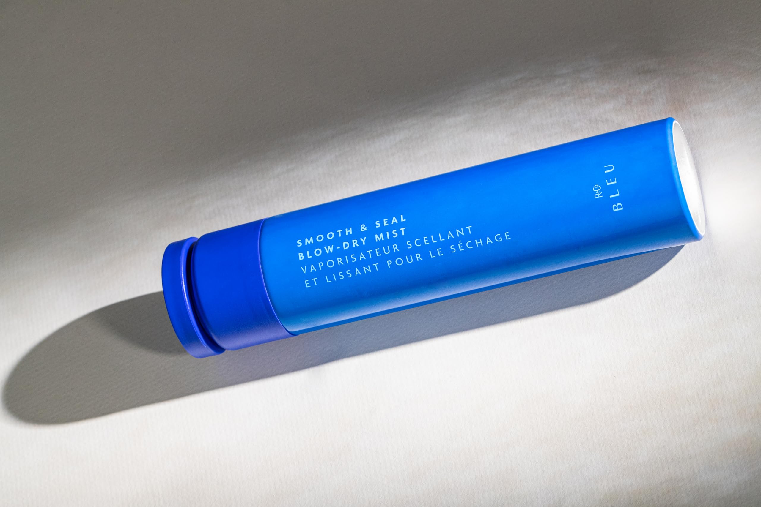 R+Co BLEU spray application close-up showing even dispersion for heat protection