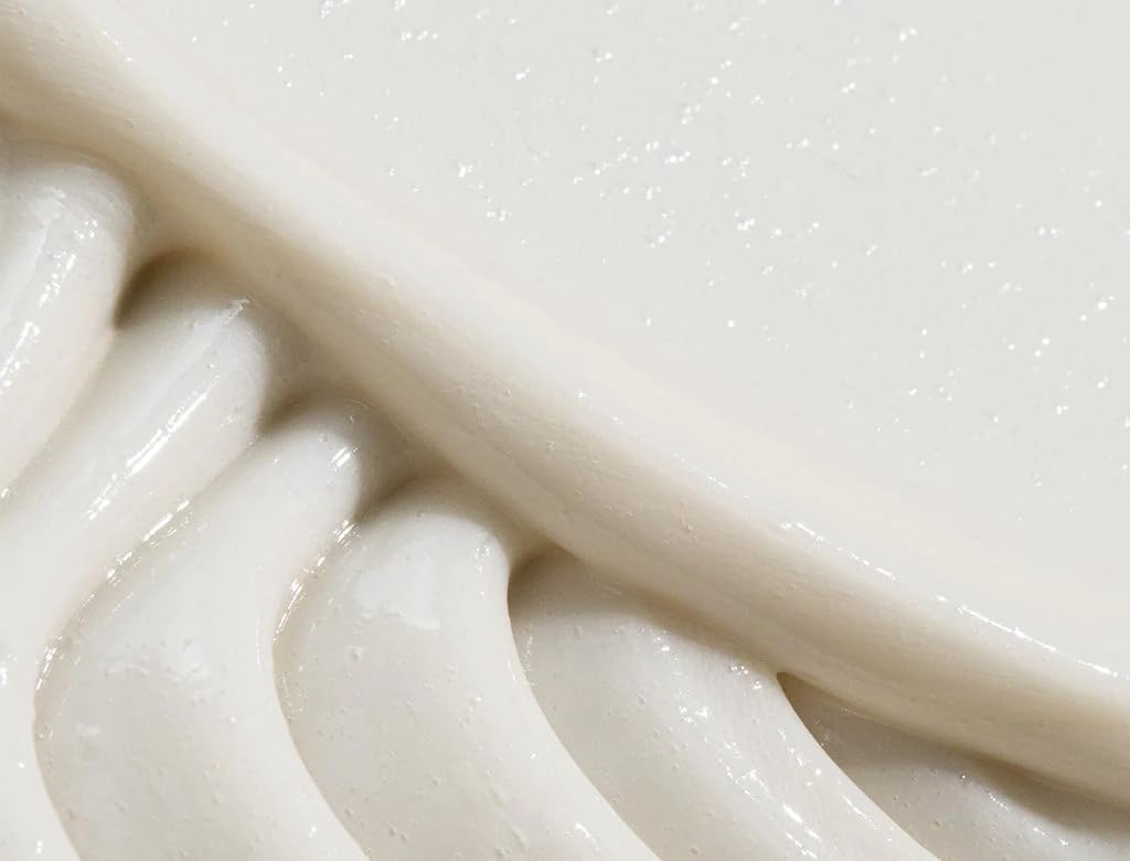 REVERIE conditioner jar close-up shows creamy texture for gentle nourishment.