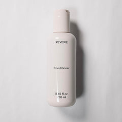REVERIE conditioner application on hair demonstrates slip and detangling ease.