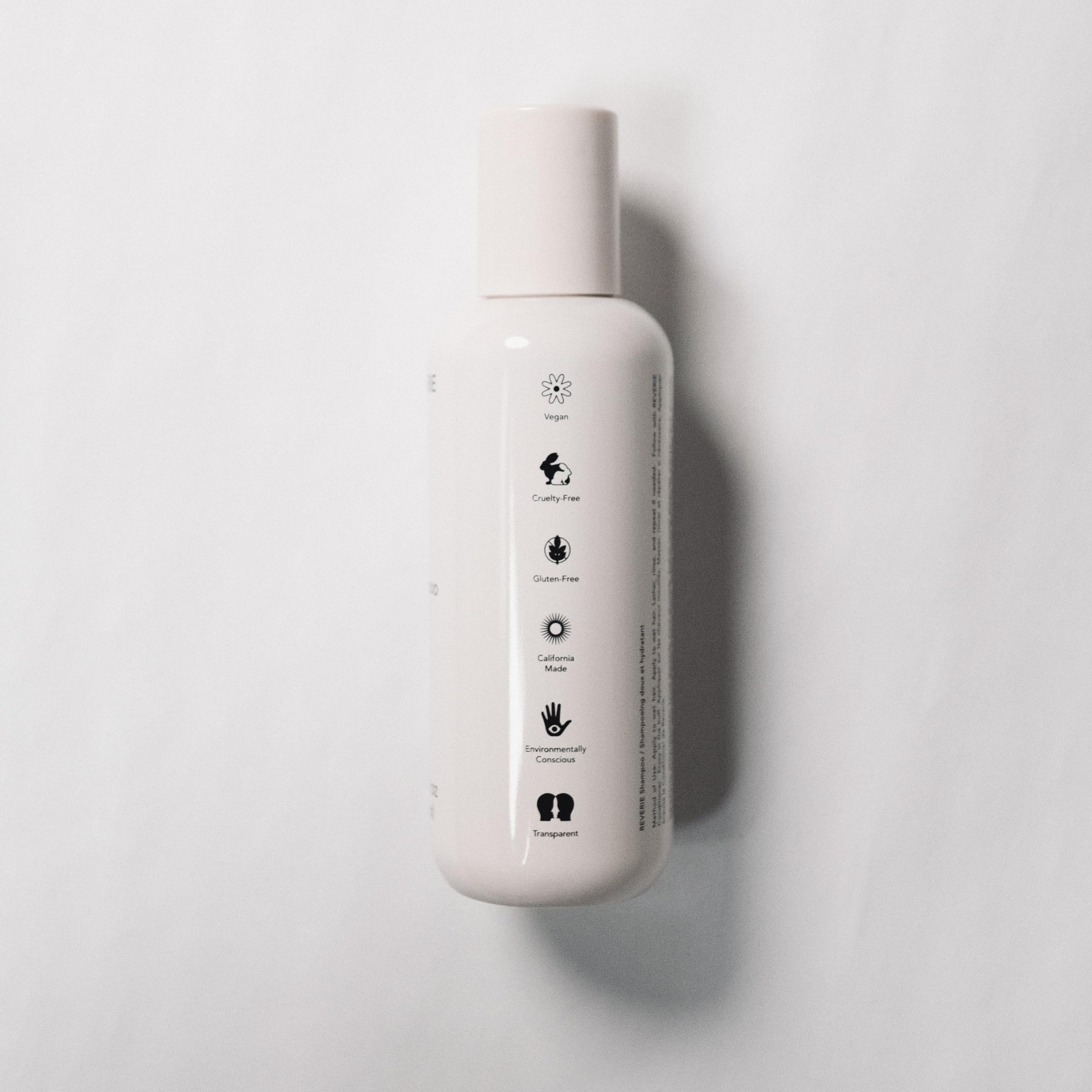 REVERIE Natural Balancing Shampoo application at sink illustrates easy distribution for scalp cleansing.