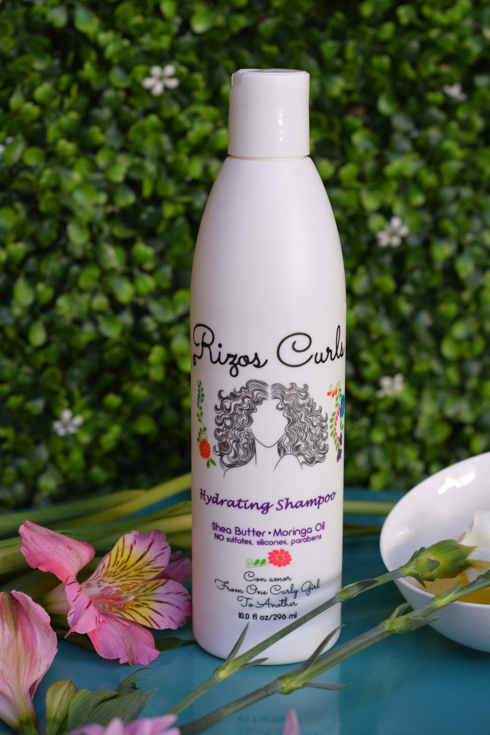 Rizos Curls Hydrating Shampoo label closeup highlights clean ingredients for gentle scalp cleansing.
