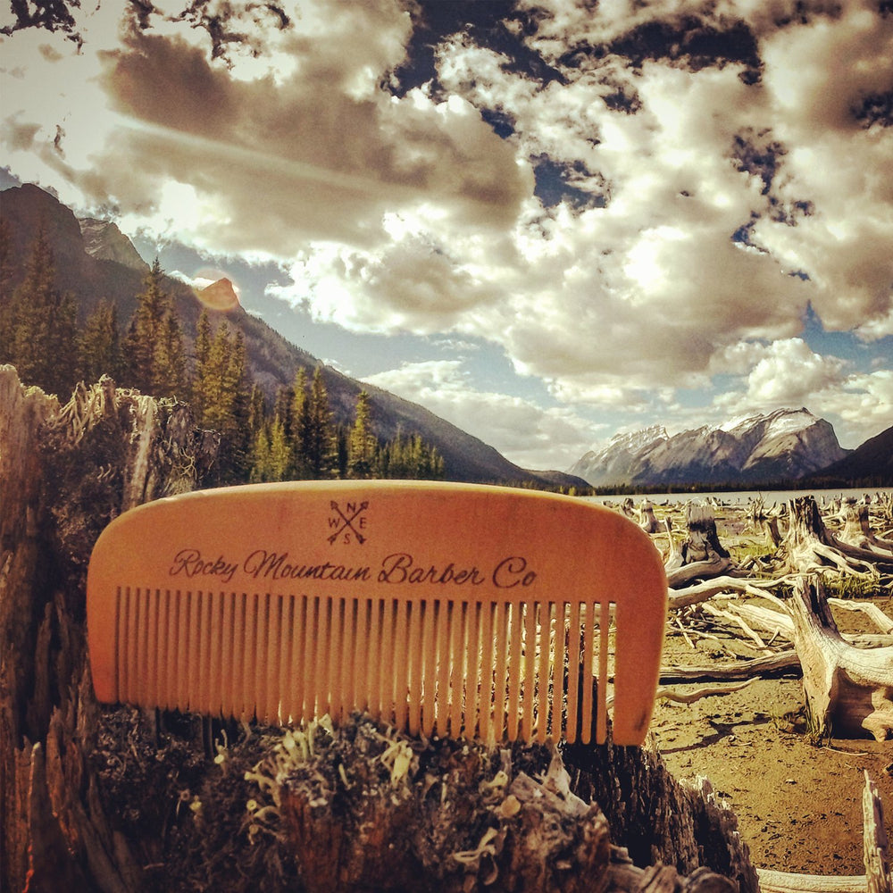 Rocky Mountain Barber Company peine de madera junto a accesorios de regalo.