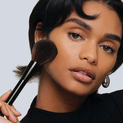 Saie brush applying setting powder for seamless natural finish