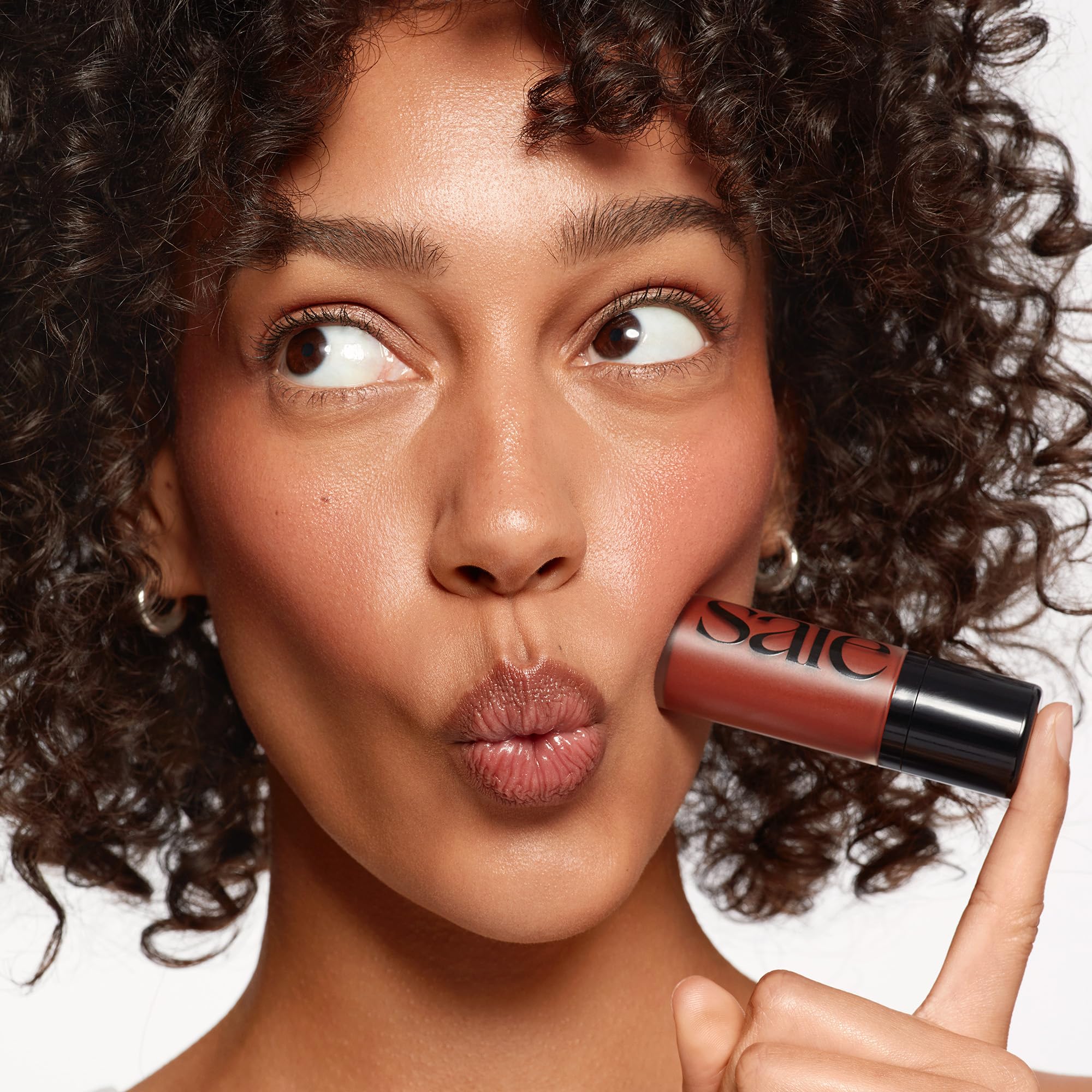 Saie Dew Liquid Blush on apple of cheek for healthy-looking radiance.