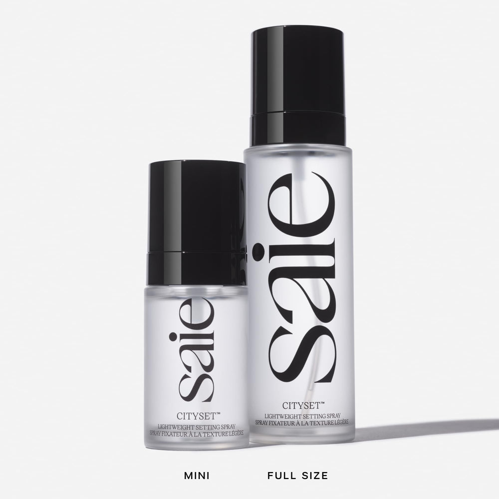 Person applying Saie mist outdoors showing long-lasting makeup refresh benefit