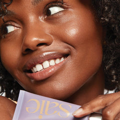 Saie Mini Sunvisor being massaged into skin with glowing finish to show dewy radiance