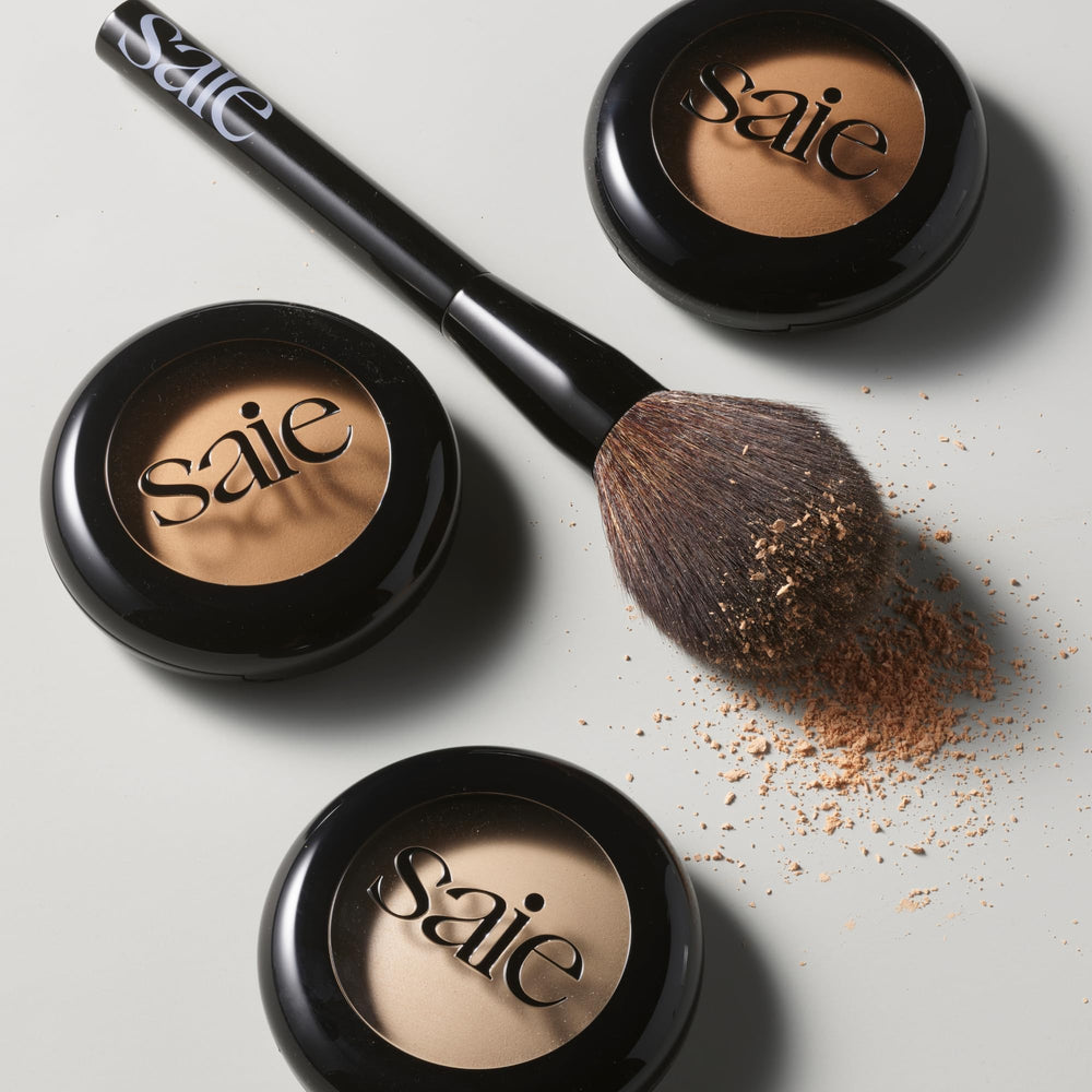 Saie brush held in hand to show scale and effortless coverage