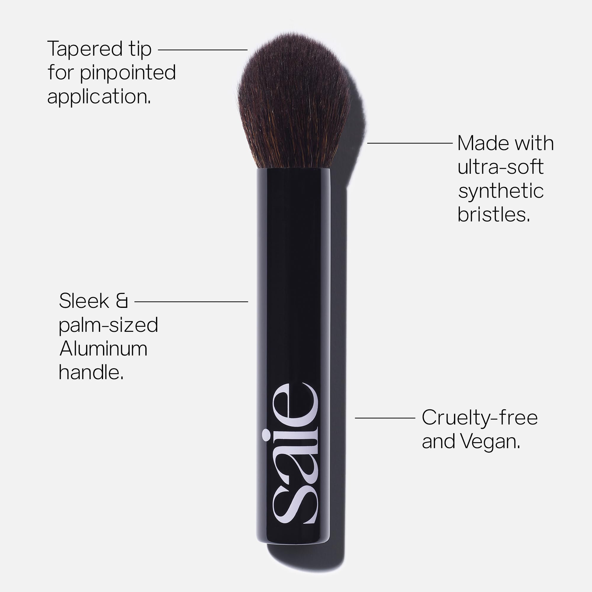 Saie The Fluffy Brush palm-handle view shows travel-friendly design for easy on-the-go touch-ups.