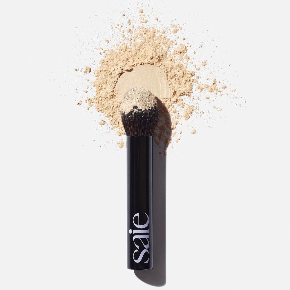 Saie The Fluffy Brush tapered-tip for pinpoint powder placement on high-shine zones.