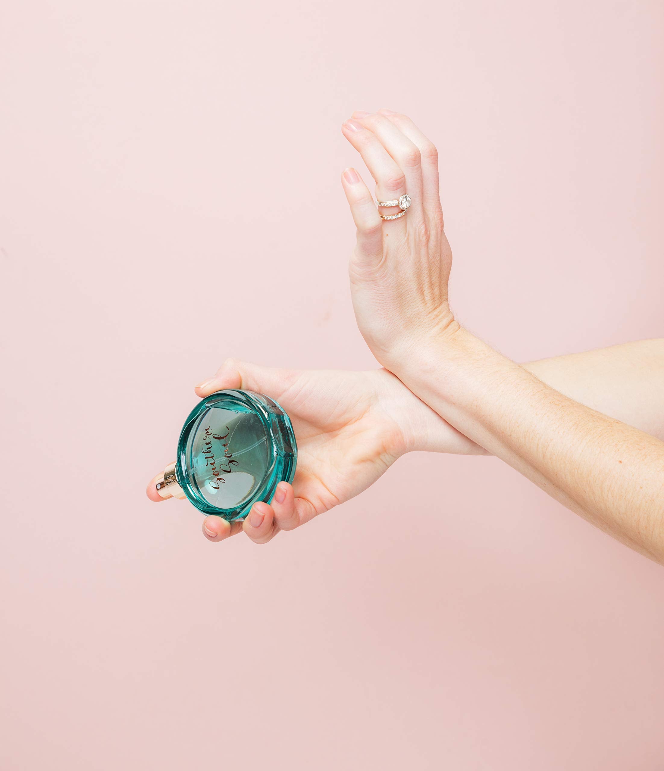 Vial in hand demonstrates portable size for on-the-go fragrance.