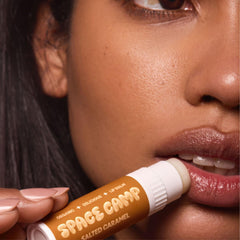 Space Camp Wellness jumbo lip balm salted caramel application on lips with smooth coverage.