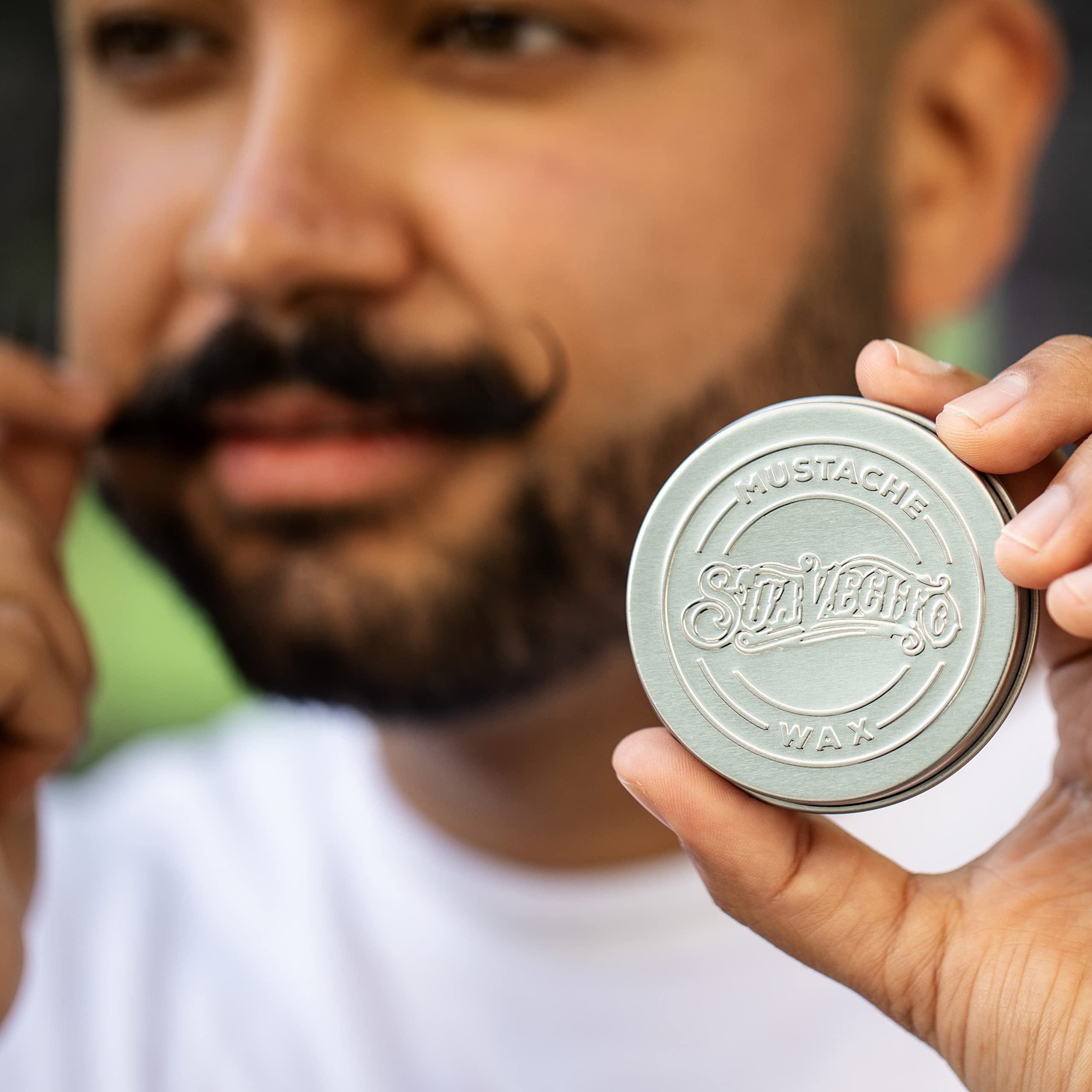 On-desk setup with Suavecito Whiskey Bar Mustache Wax within easy reach.