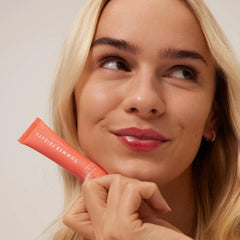 Summer Fridays Tinted Lip Butter Poppy packaging conveys soft, cruelty-free nourishment in a chic tube.