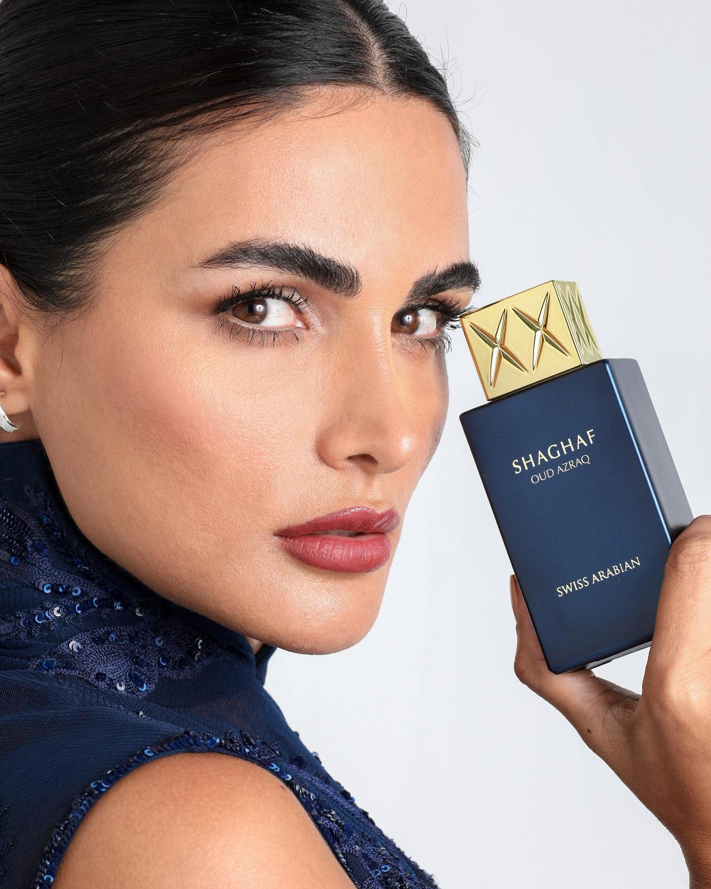 Swiss Arabian Shaghaf Oud Azraq glass-gold cap close-up conveys display-worthy luxury.